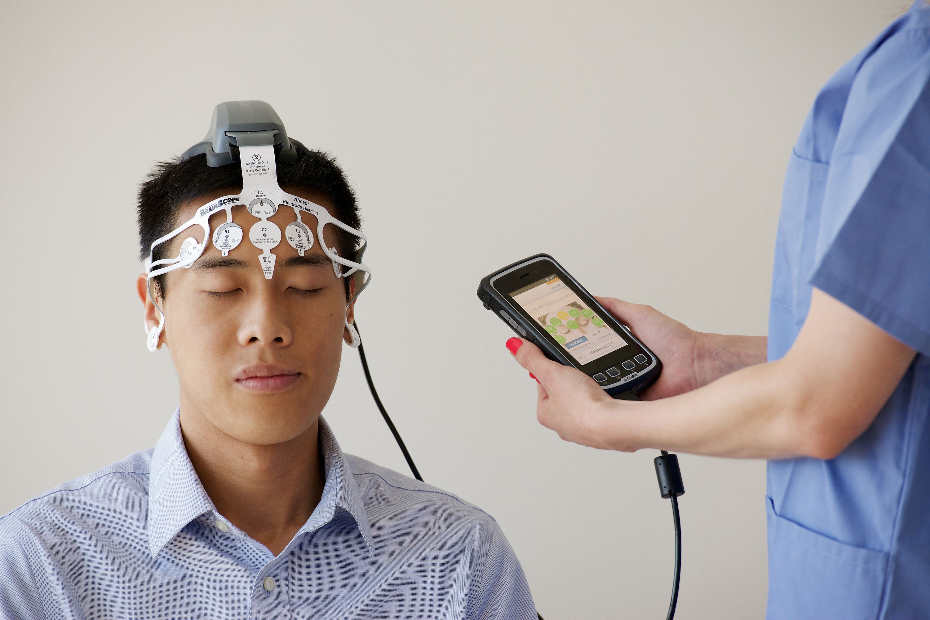 EEG technician performing an electroencephalogram on a patient EEG technician performing an electroencephalogram on a patient